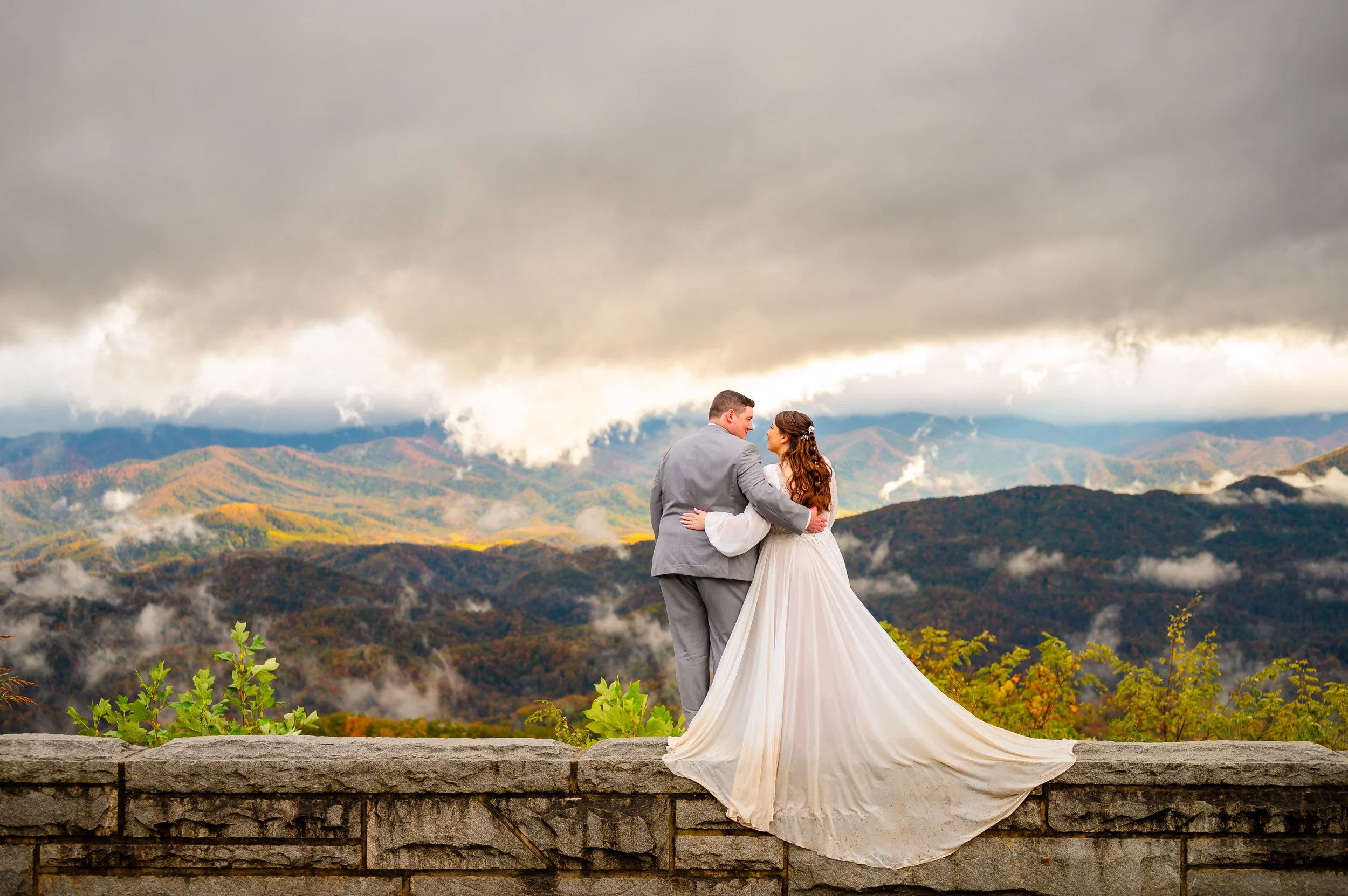Couple at the stone wall of a Foothills Parkway overlook with clouds over the Smoky Mountains — Gatlinburg, TN